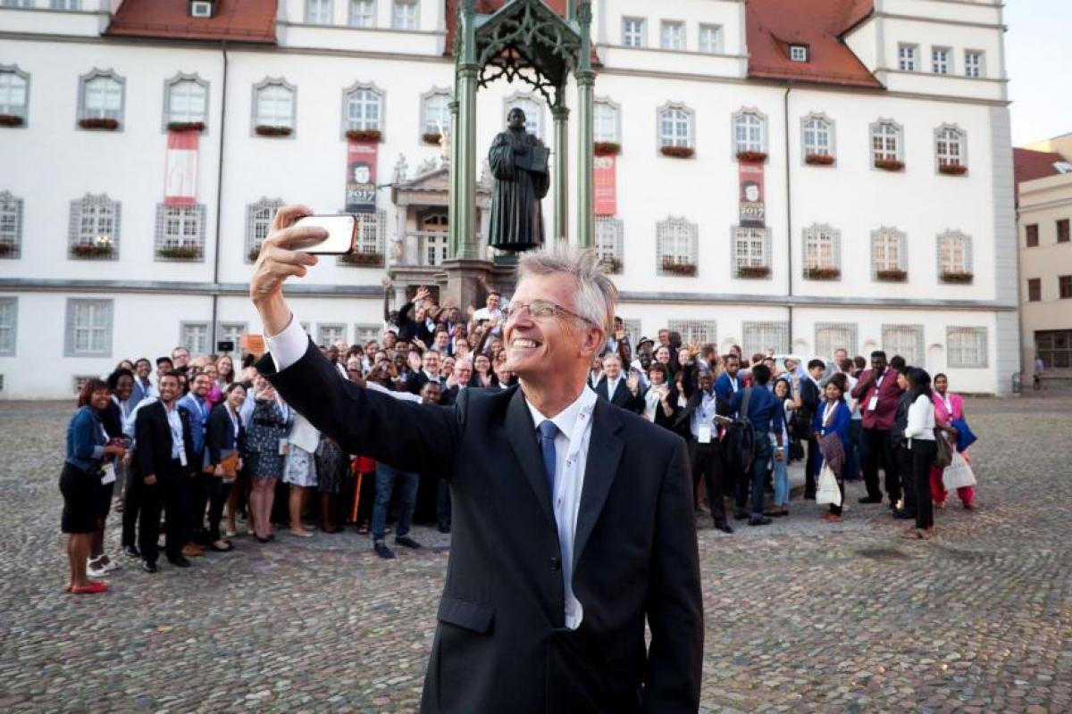 LWF General Secretary Rev Dr Martin Junge posing with young reformers and a statue of Martin Luther in Wittenberg, Germany