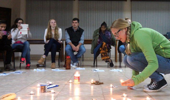 A participant at the international youth gathering in Brazil lights a candle
